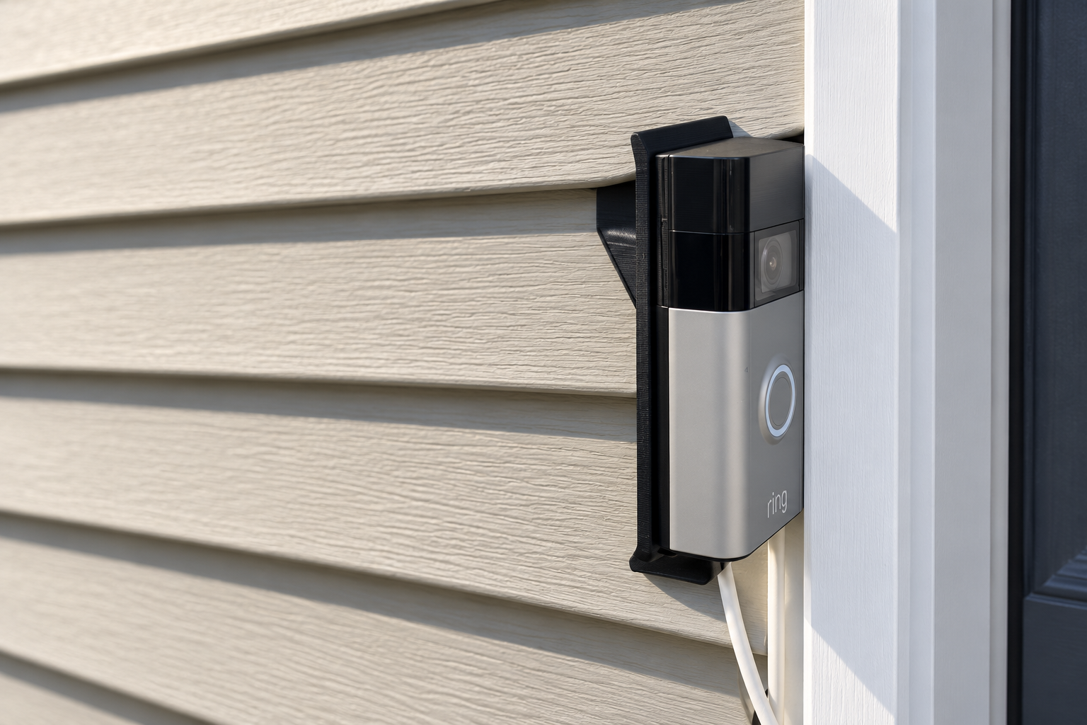 Video doorbell on a black siding mount beside white door trim